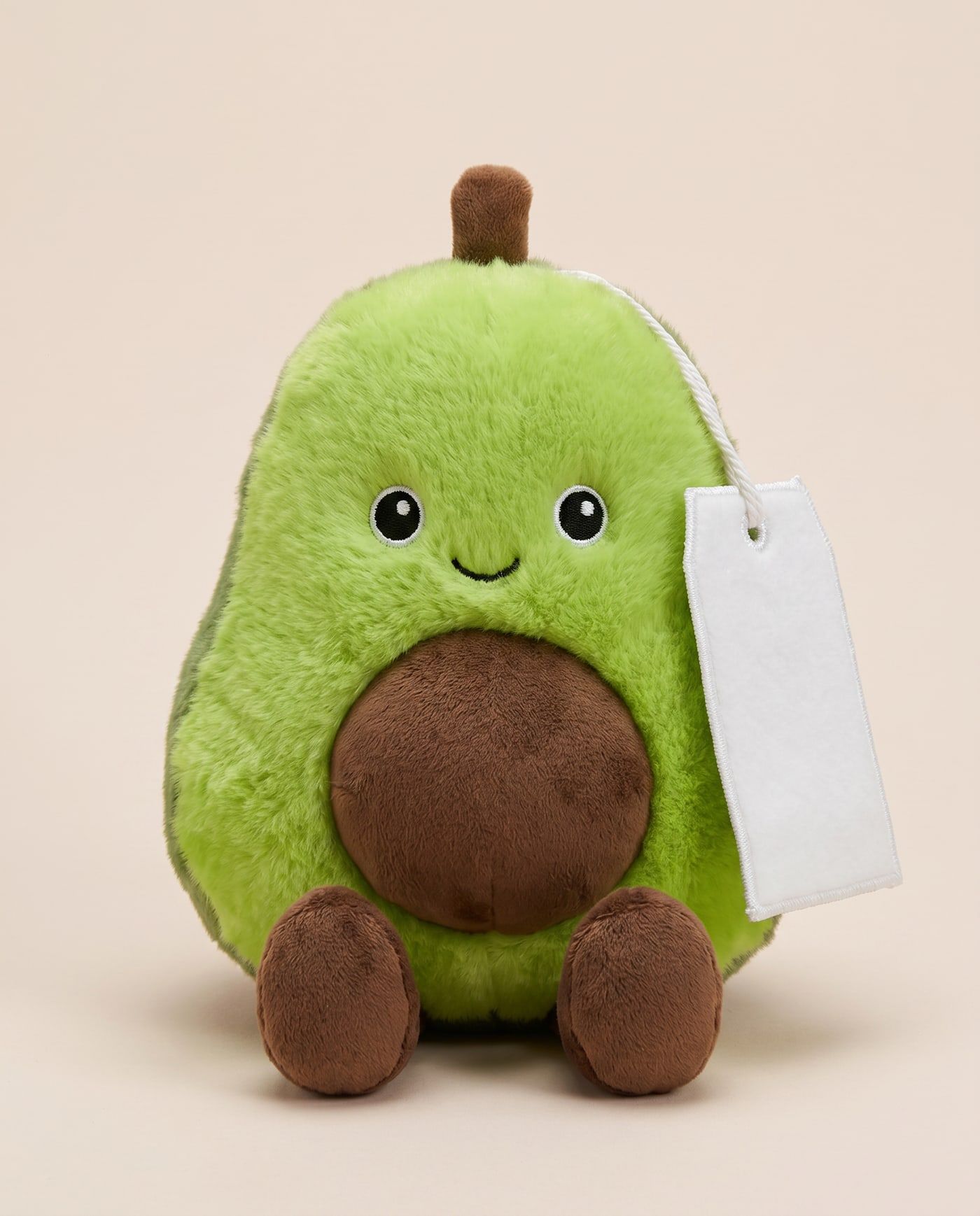 Arlo the Avocado TagTales plush sitting down, showing the blank white fleece personalisation tag