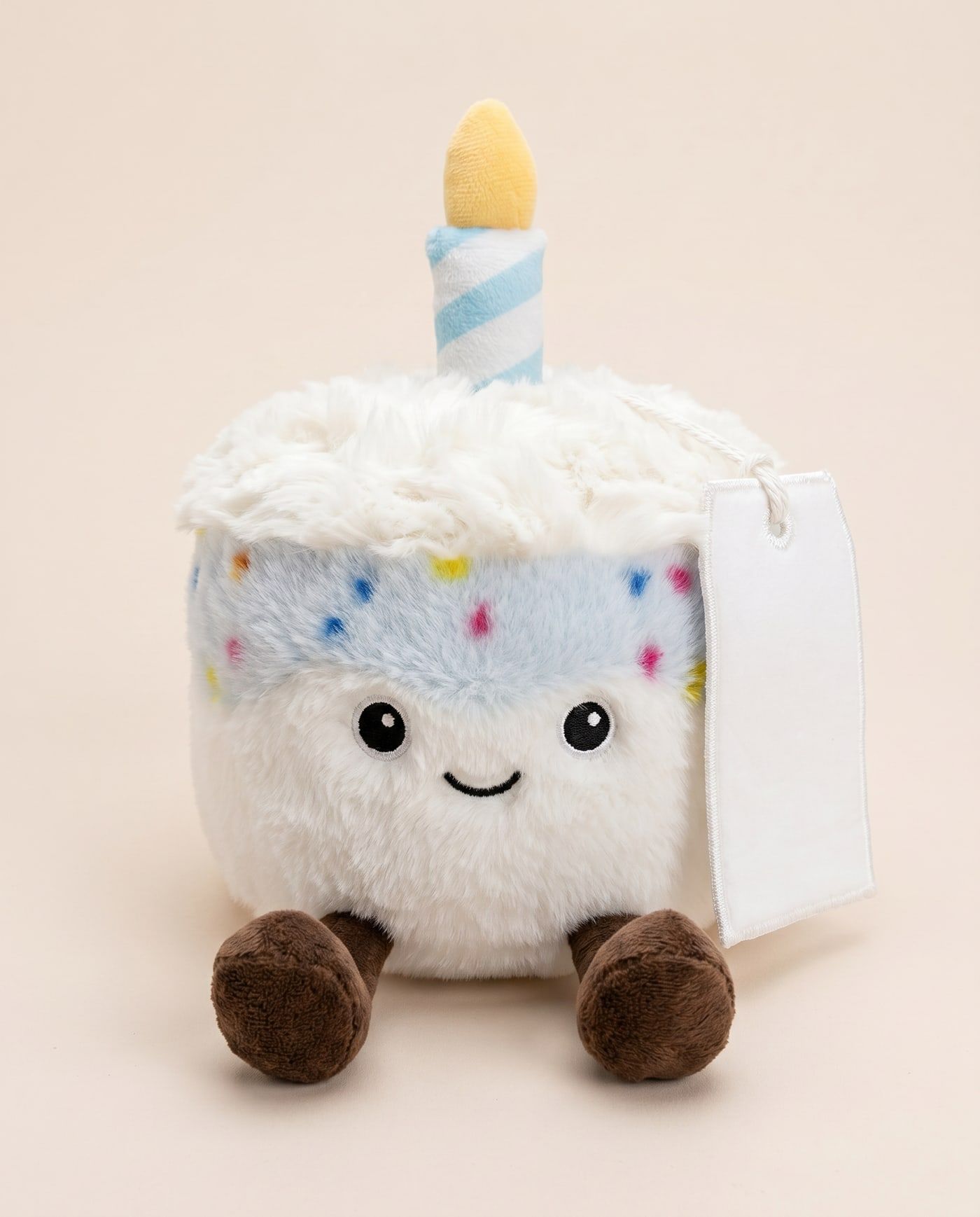 Bobby the Birthday Cake (Blue) TagTales plush sitting down, showing the blank white fleece personalisation tag