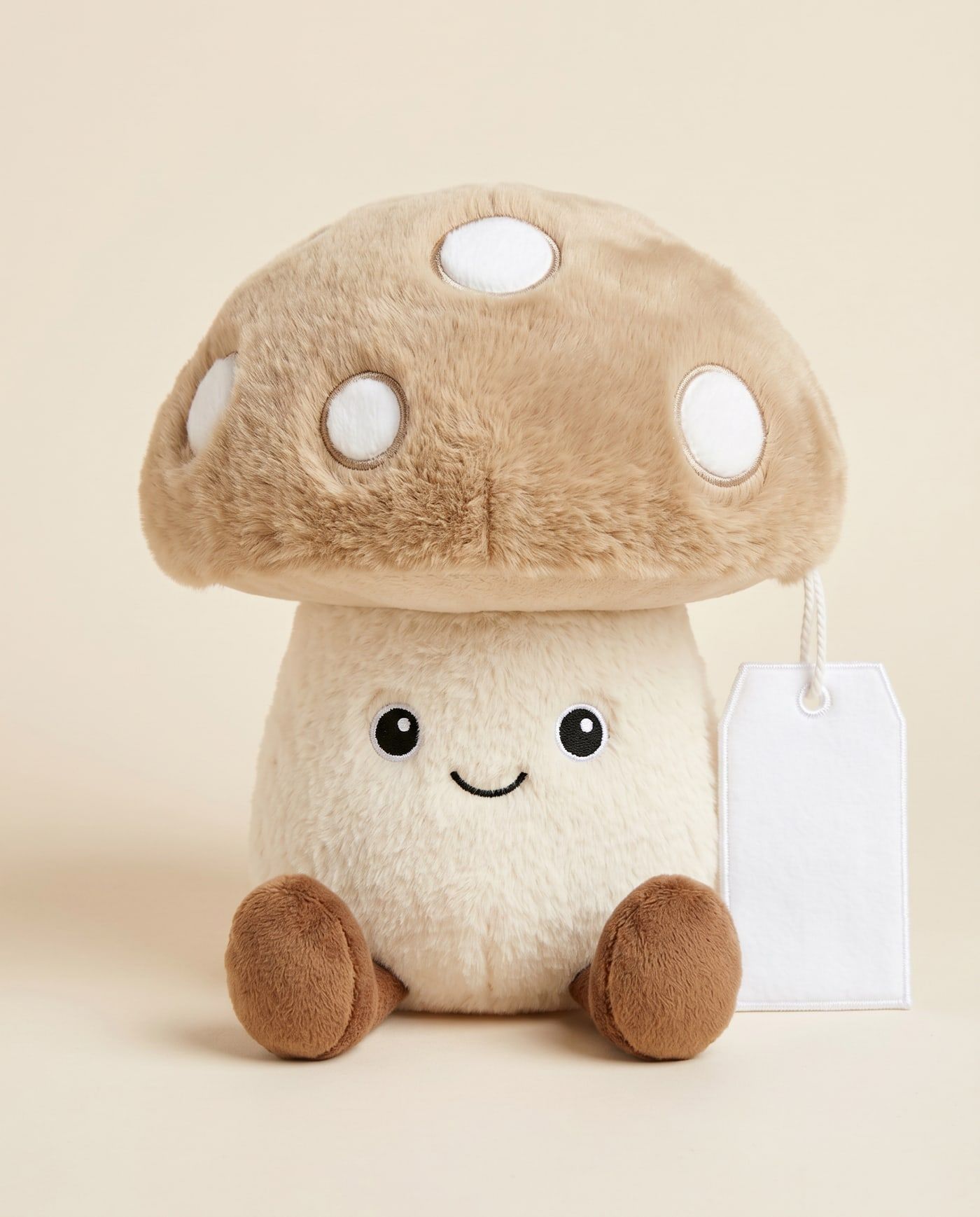 Mouch the Mushroom TagTales plush sitting down, showing the blank white fleece personalisation tag
