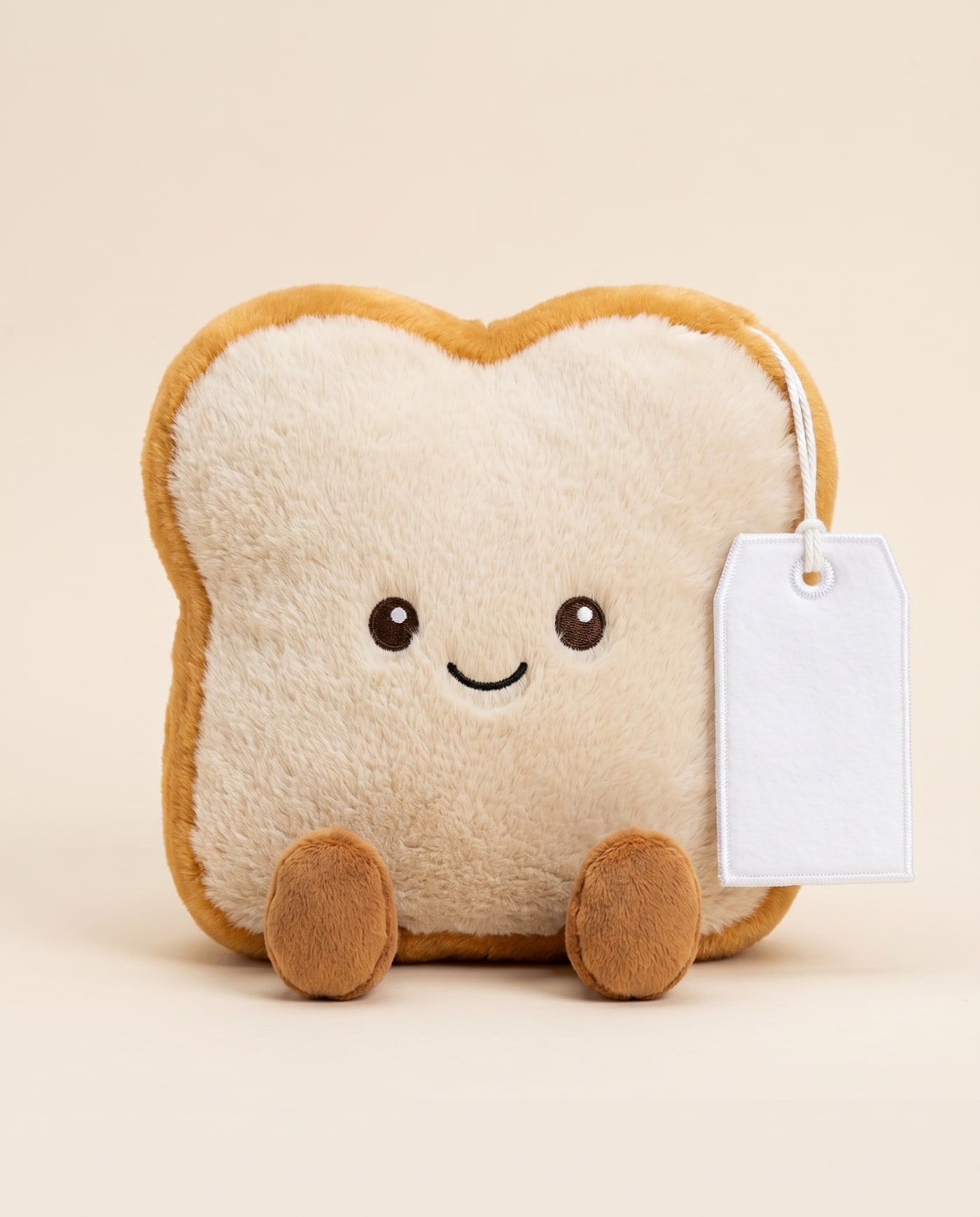 Toby the Toast TagTales plush sitting down, showing the blank white fleece personalisation tag
